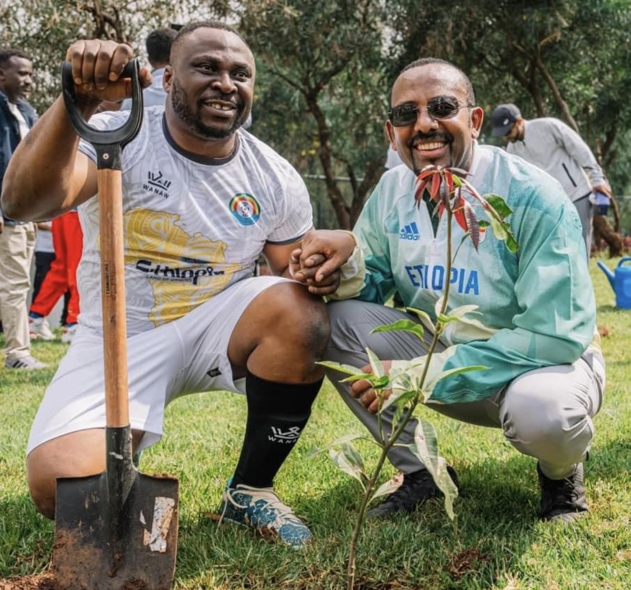 Prime Minister Abiy Ahmed and an African football legend taking part in a tree-planting activity